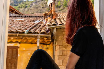 Rear view of woman holding umbrella