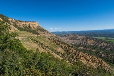 Scenic view of mountains against blue sky