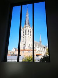 Buildings against sky seen through window