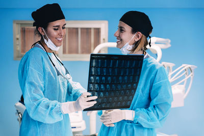 Surgeons examining x-ray image while standing in operating room