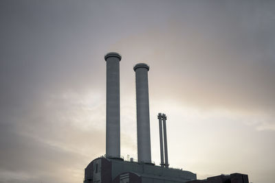 Low angle view of smoke emitting from chimney against sky