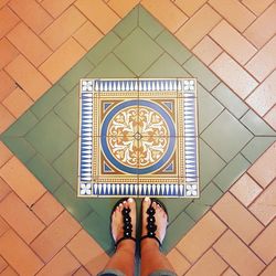 Low section of woman standing on tiled floor