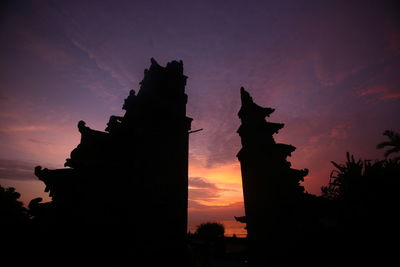 Low angle view of silhouette built structures against sky