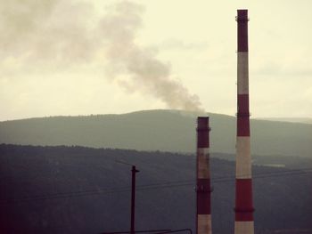 Smoke emitting from chimney against sky