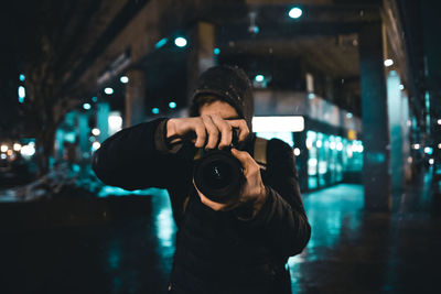 Man photographing in illuminated city at night