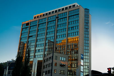 Low angle view of modern building against blue sky