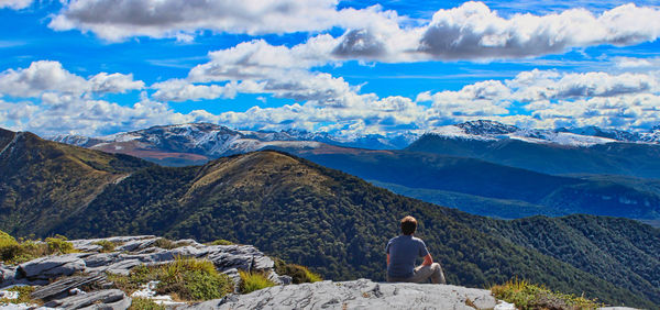 Rear view of woman looking at snowcapped mountain against sky