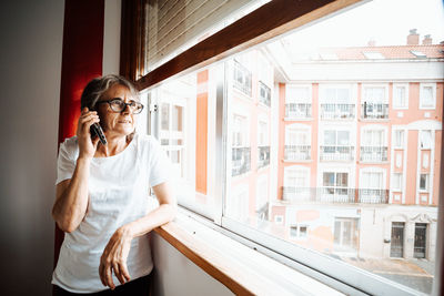 Full length of woman standing by window