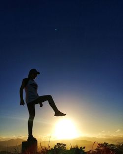 Silhouette man standing against sky during sunset