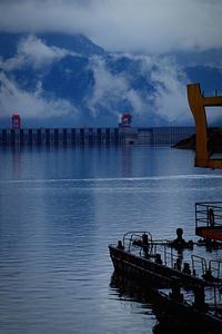 Pier on sea against cloudy sky