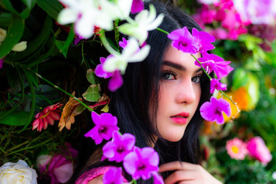 Close-up portrait of woman with pink flowers