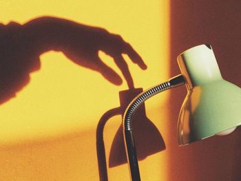 Close-up of human hand on table against wall