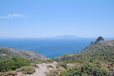 Scenic view of sea and mountains against blue sky