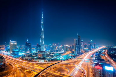 High angle view of light trails on road against buildings