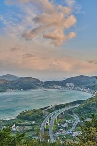 High angle view of sea and city against sky during sunset