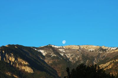 Low angle view of mountain against blue sky