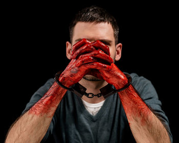 Close-up of man holding food against black background