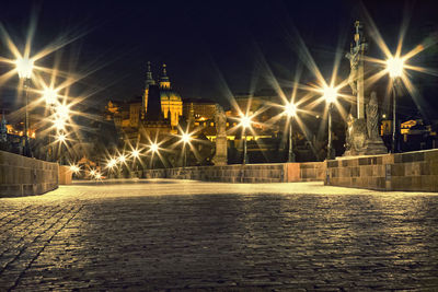 Illuminated street lights by buildings in city at night