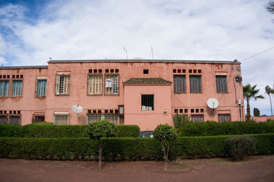 Residential building by street against sky