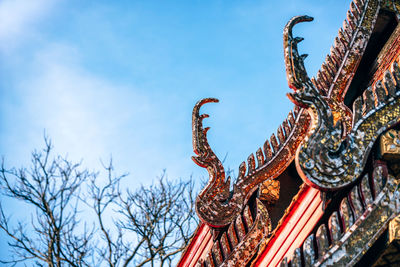 Low angle view of sculpture on building against sky