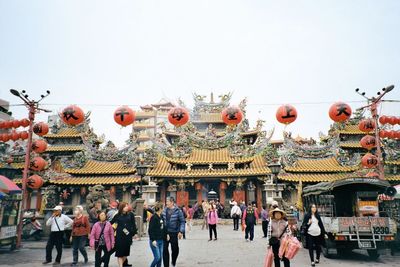 People in amusement park against clear sky