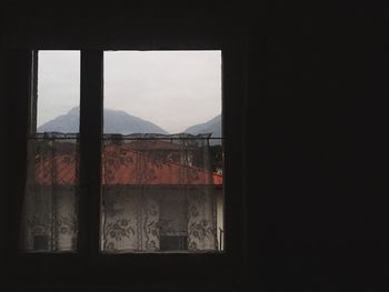 View of mountain through open window