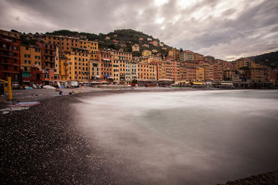 Camogli at sea shore against cloudy sky