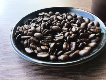 High angle view of coffee beans in bowl on table