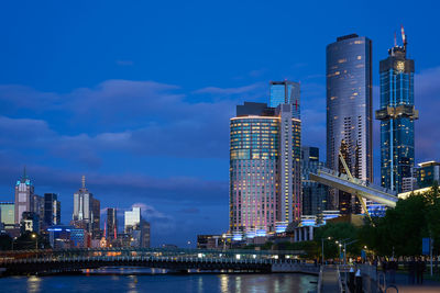 Illuminated buildings in city against sky