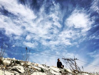 Low angle view of man standing against sky