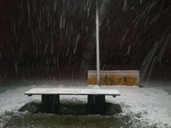 Bench in park during winter at night