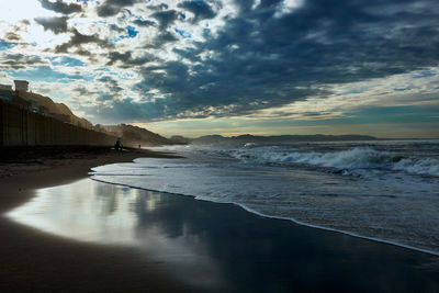 Scenic view of beach against sky during sunrise