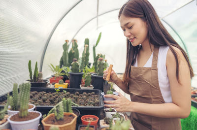 Woman standing by potted plant