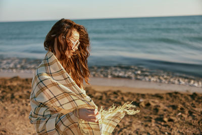 Rear view of woman standing at beach