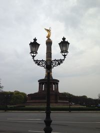 Low angle view of street light against cloudy sky