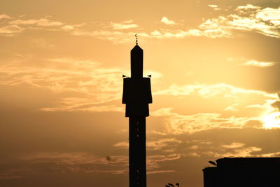 Low angle view of silhouette cross against sky during sunset