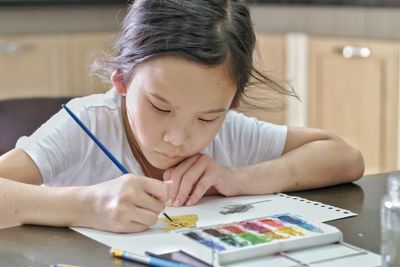 Portrait of a girl making face on table