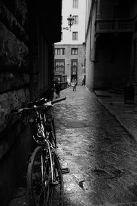 Bicycle parked on street amidst buildings