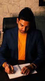 Young man sitting on book