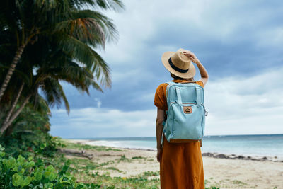 Man standing at beach against sky