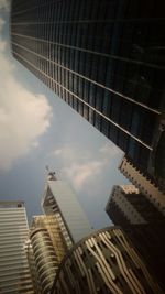 Low angle view of modern building against cloudy sky