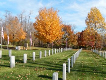 Trees in cemetery against sky during autumn