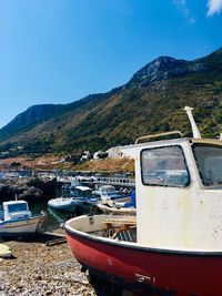 Boats moored at shore against clear blue sky