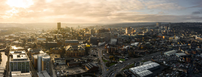 High angle view of city buildings against cloudy sky