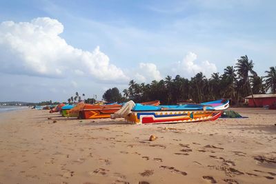 Boats moored on beach against sky