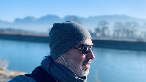 Close-up of man wearing sunglasses and knit hat standing outdoors during winter