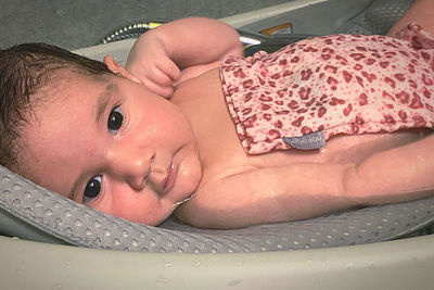 Portrait of cute baby lying on bed