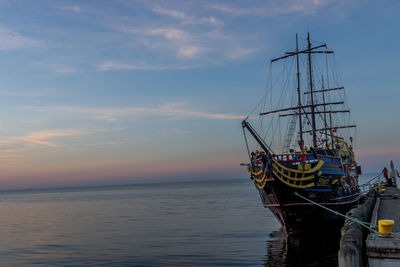 Sailboat in sea against sky during sunset