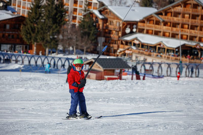 Full length of woman skiing on snow covered field