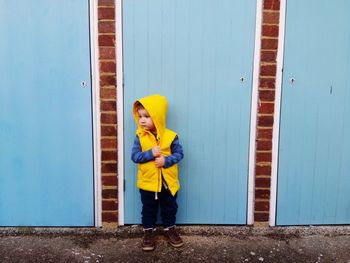 Cute boy standing against wall